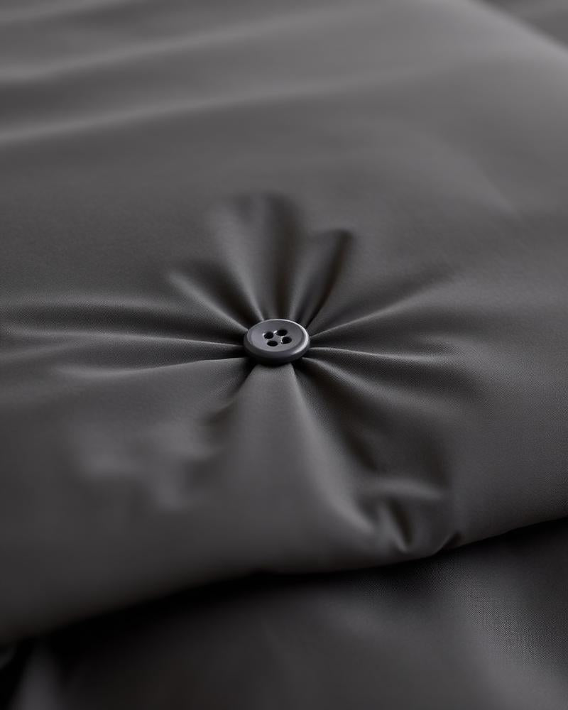 Close-up charcoal grey sateen duvet button detail